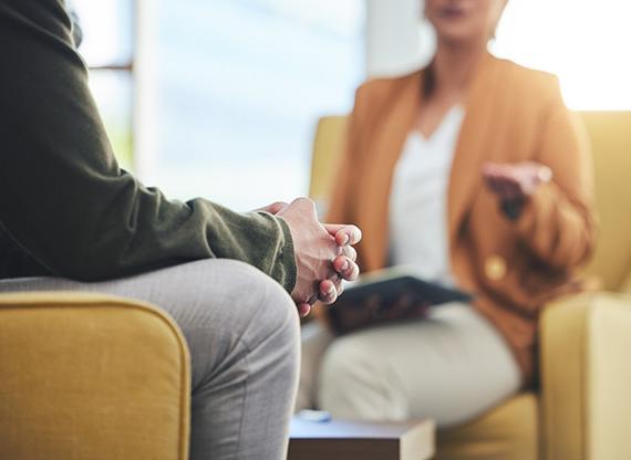 Image of therapist conversing with an individual in a mental health setting